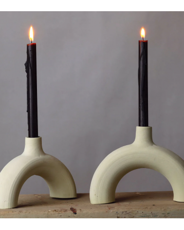 Bougeoir arc en céramique brute avec chandelles noires, style minimaliste.