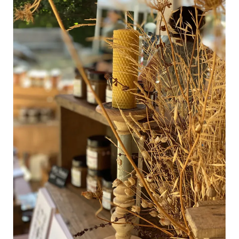 Bougie en cire d'abeille allumée dans un décor chaleureux et authentique.