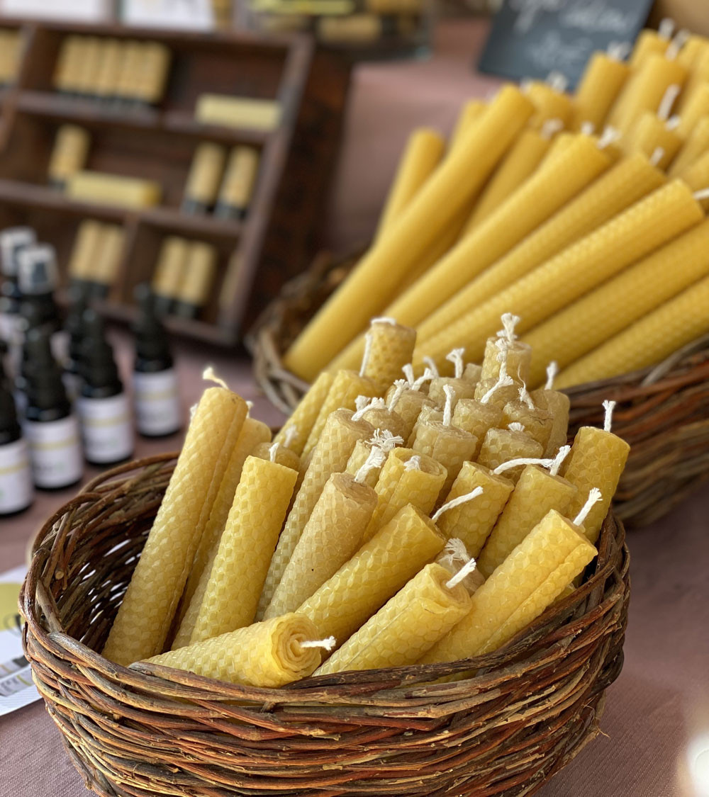 Bougies en cire d'abeille disposées dans un panier pour une ambiance rustique.