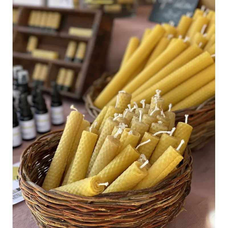 Bougies en cire d'abeille disposées dans un panier pour une ambiance rustique.