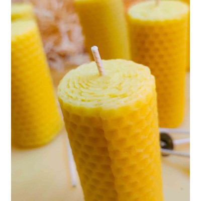 Bougie en cire d'abeille naturelle, montrant sa texture alvéolée et sa mèche artisanale.