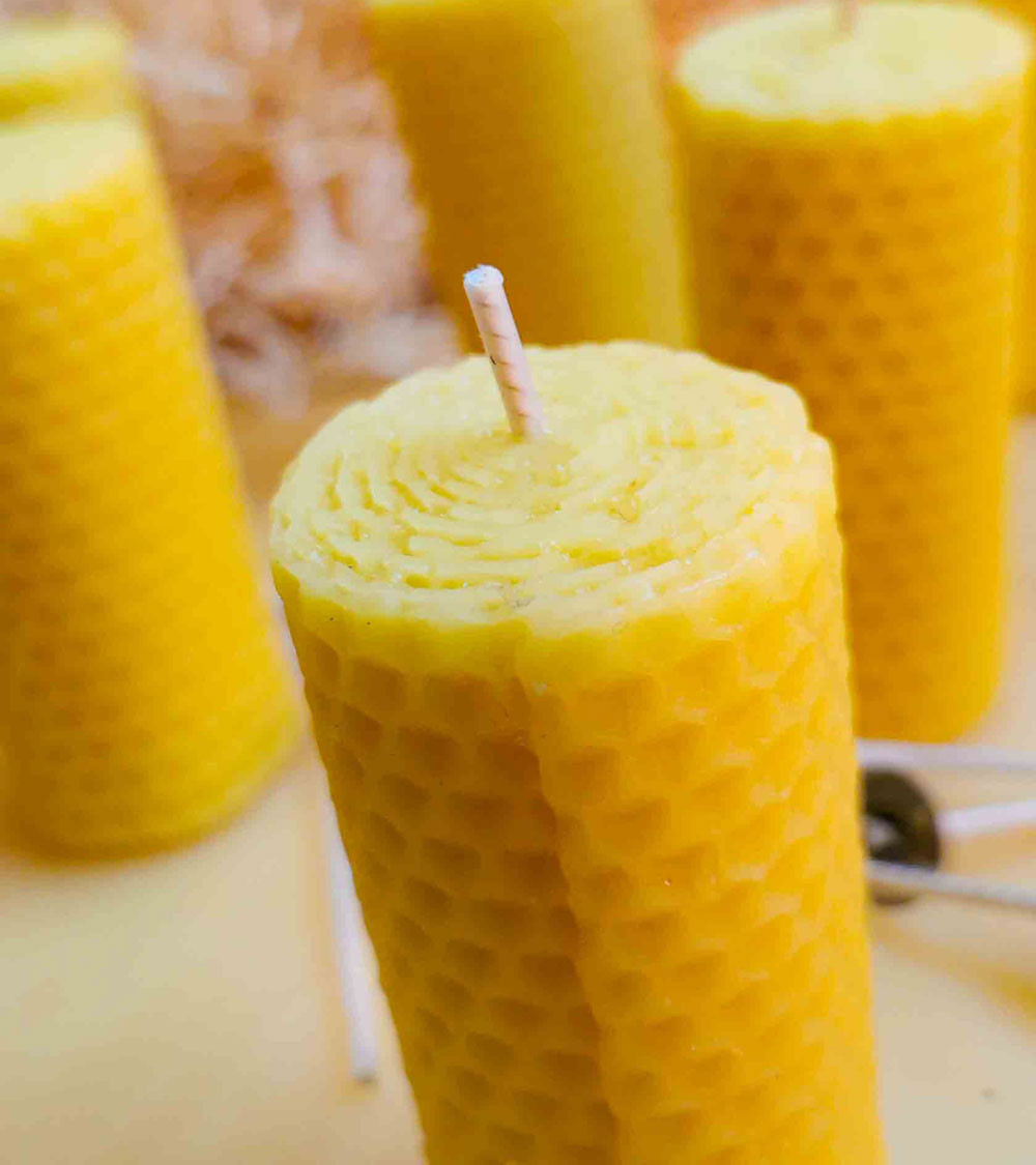 Bougie en cire d'abeille naturelle, montrant sa texture alvéolée et sa mèche artisanale.