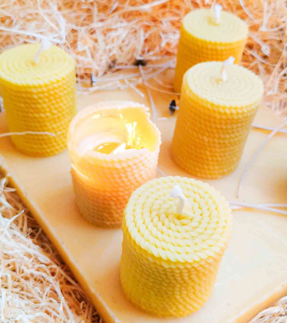 Ensemble de bougies artisanales en cire d’abeille sur fond naturel, parfaites pour une ambiance chaleureuse.