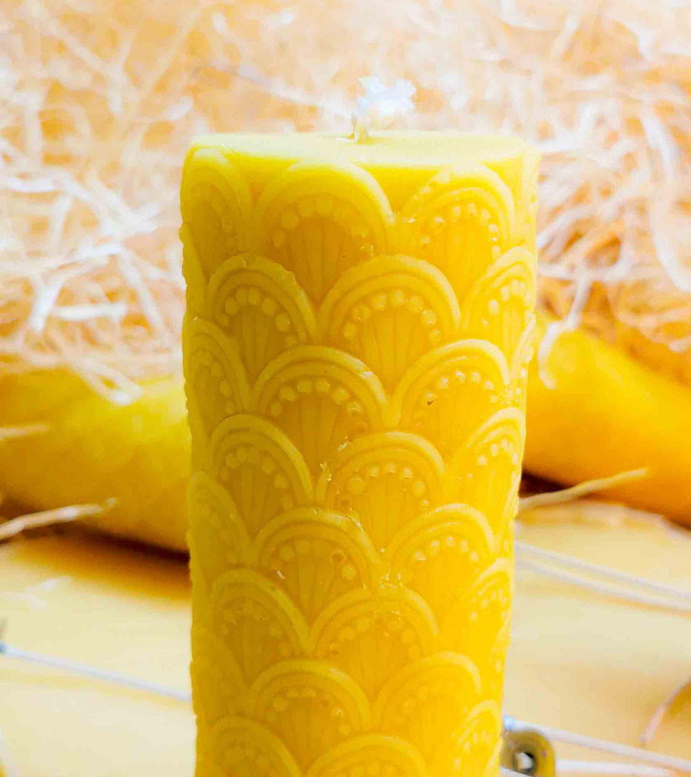 Vue rapprochée de la bougie cathédrale en pure cire d'abeille montrant la finesse de son motif
