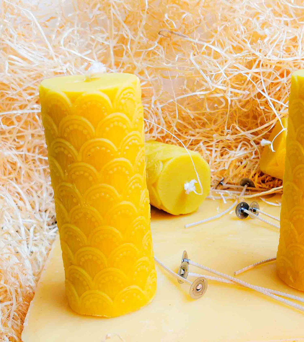 Plusieurs bougies cathédrales en cire d'abeille disposées dans un décor naturel