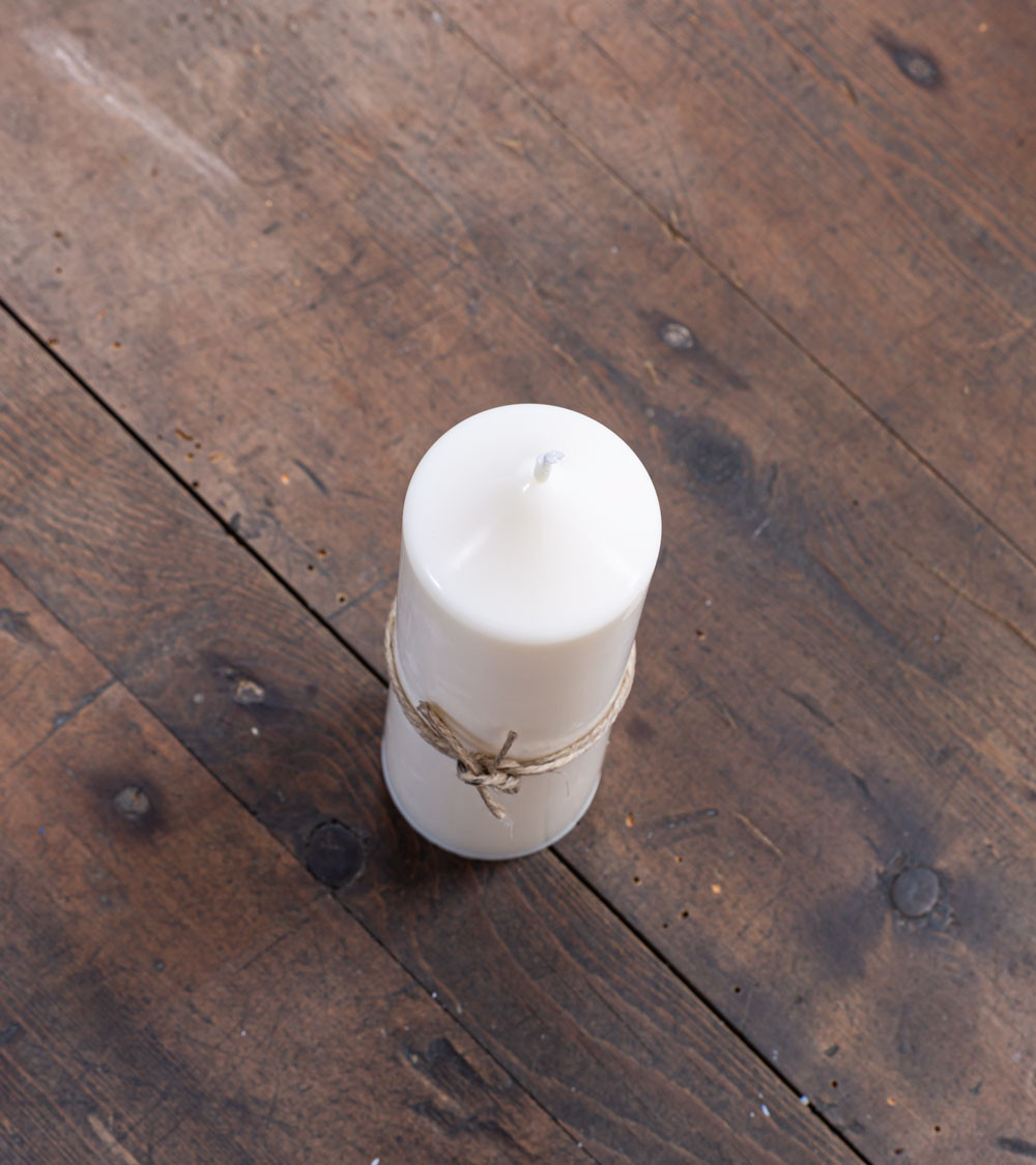 Bougie naturelle et artisanale Ø 5 cm H 14 cm sur table en bois, idéale pour une décoration écoresponsable