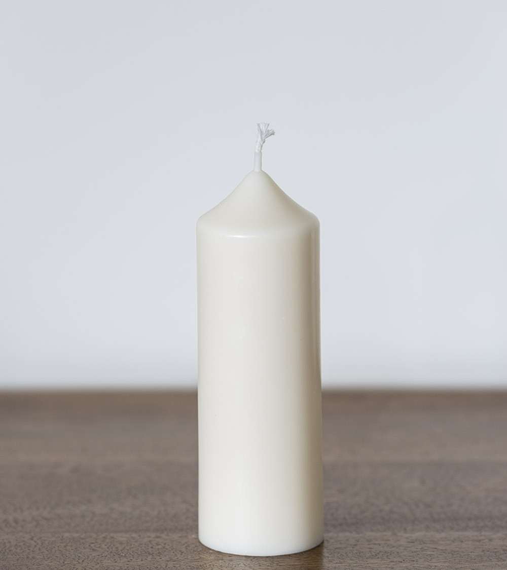 Bougie naturelle en cire de colza Ø 5 cm H 14 cm placée sur une table en bois