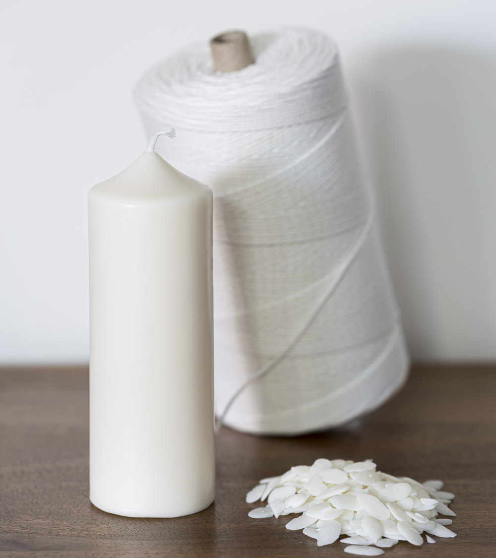 Bougie naturelle en cire de colza avec mèche et paillettes sur table en bois