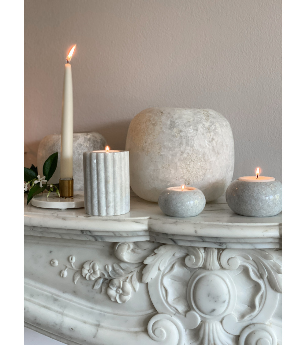 Bougeoir en marbre L placé sur une cheminée en marbre, entouré de bougies et d’éléments naturels pour une ambiance douce.