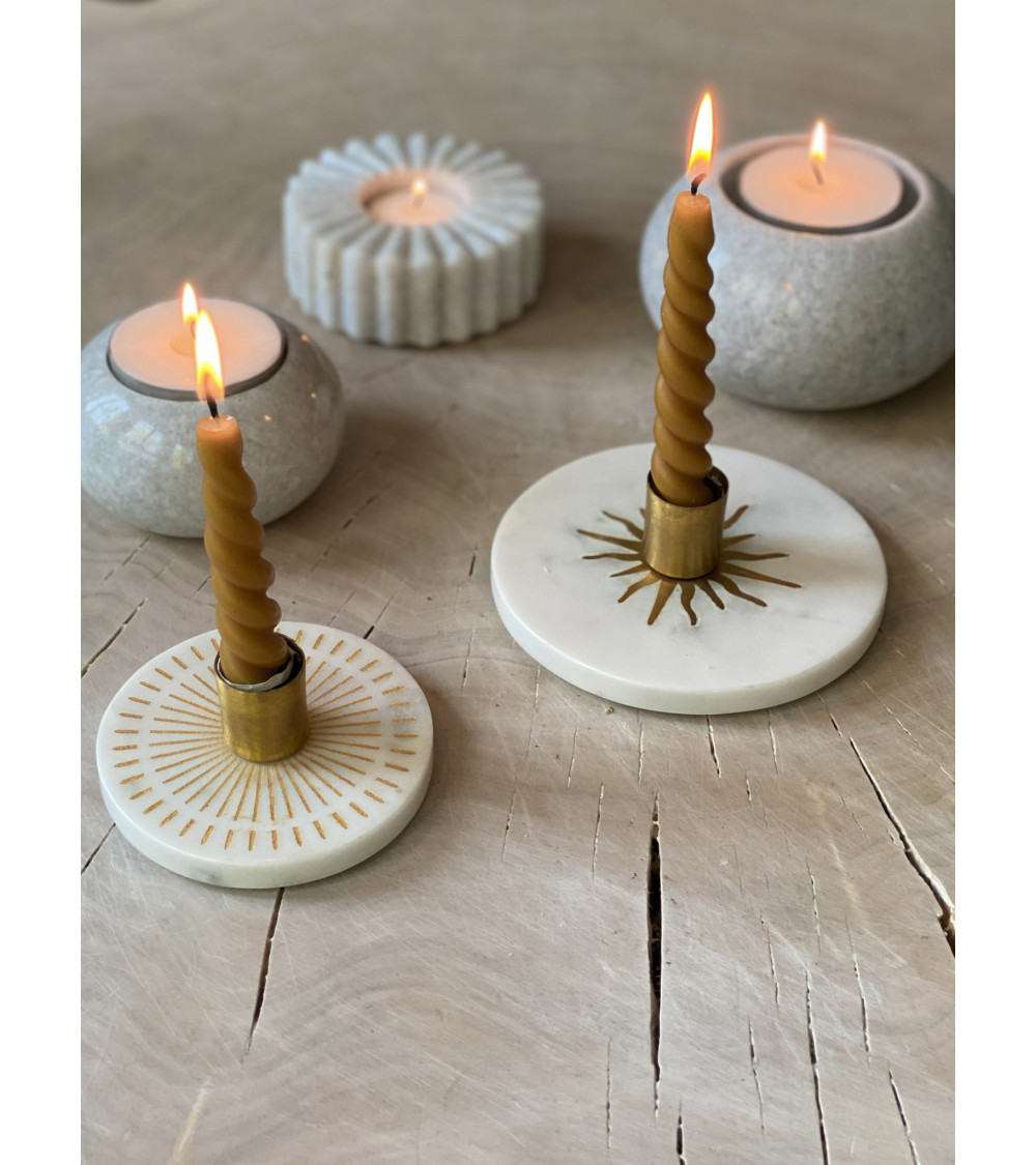 Ambiance chaleureuse avec le bougeoir en marbre L, intégré dans une composition décorative avec d’autres objets en pierre.