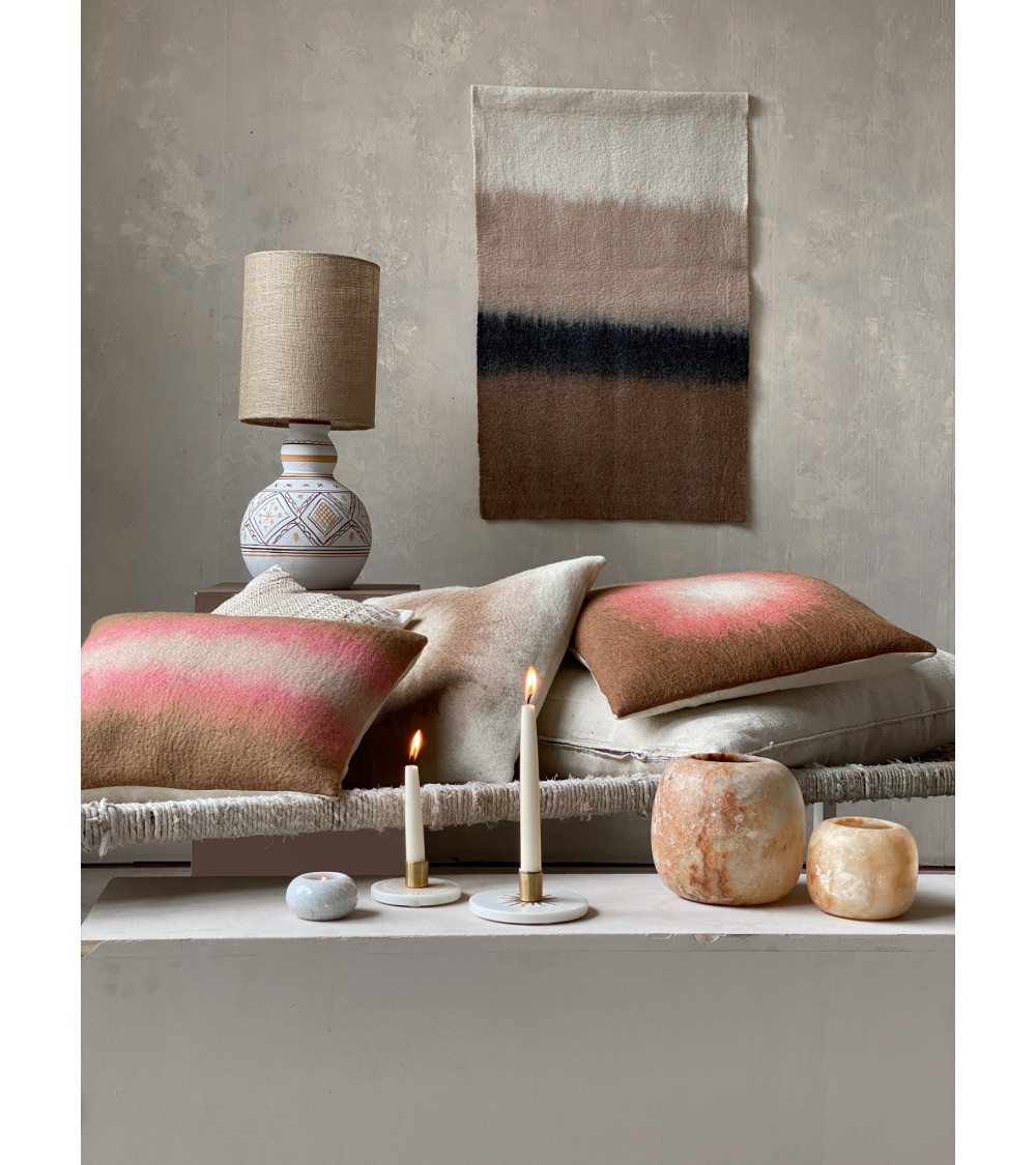 Scène de salon, le bougeoir en marbre L accompagne des coussins et objets décoratifs, créant une atmosphère accueillante.