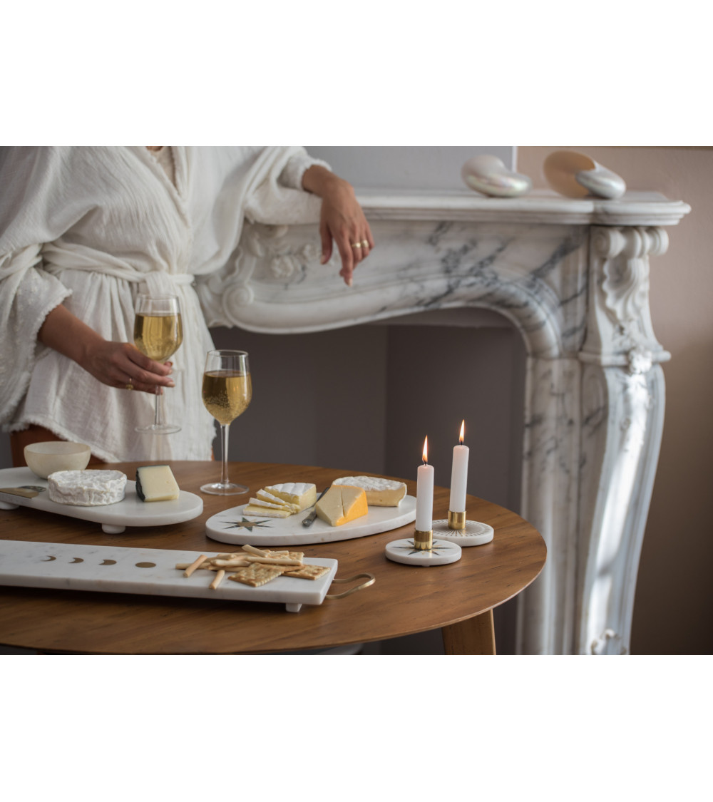 Ambiance cosy avec bougeoirs en marbre sur une table de dégustation.
