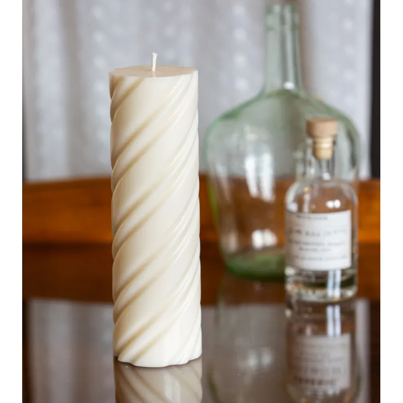 Bougie naturelle et artisanale en cire de colza Ø 7 cm H 23 cm sur une table en verre