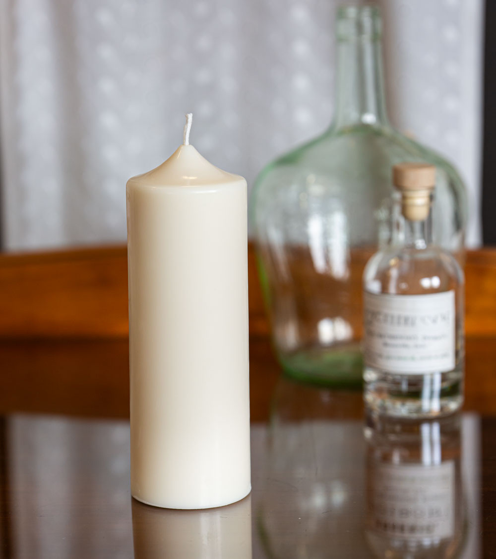 Bougie naturelle et artisanale en cire de colza Ø 7 cm H 18,5 cm sur table en verre