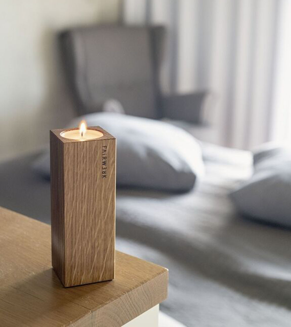 Bougeoir en chêne avec bougie chauffe-plat allumée.