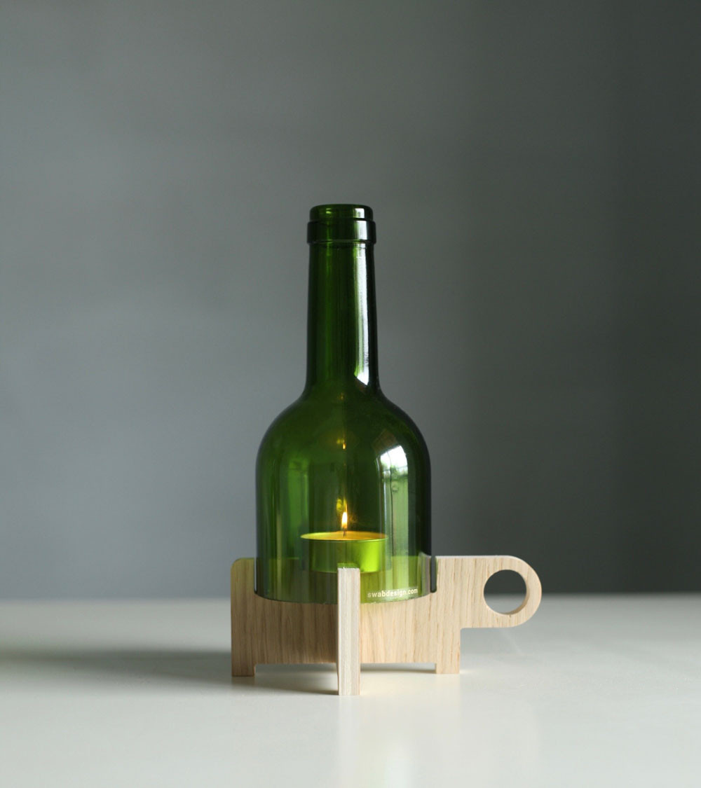 Cloche en verre positionnée sur le bougeoir en bois.