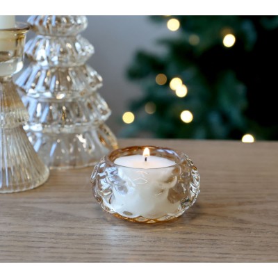 Photophore en verre ambré allumé, ambiance festive.