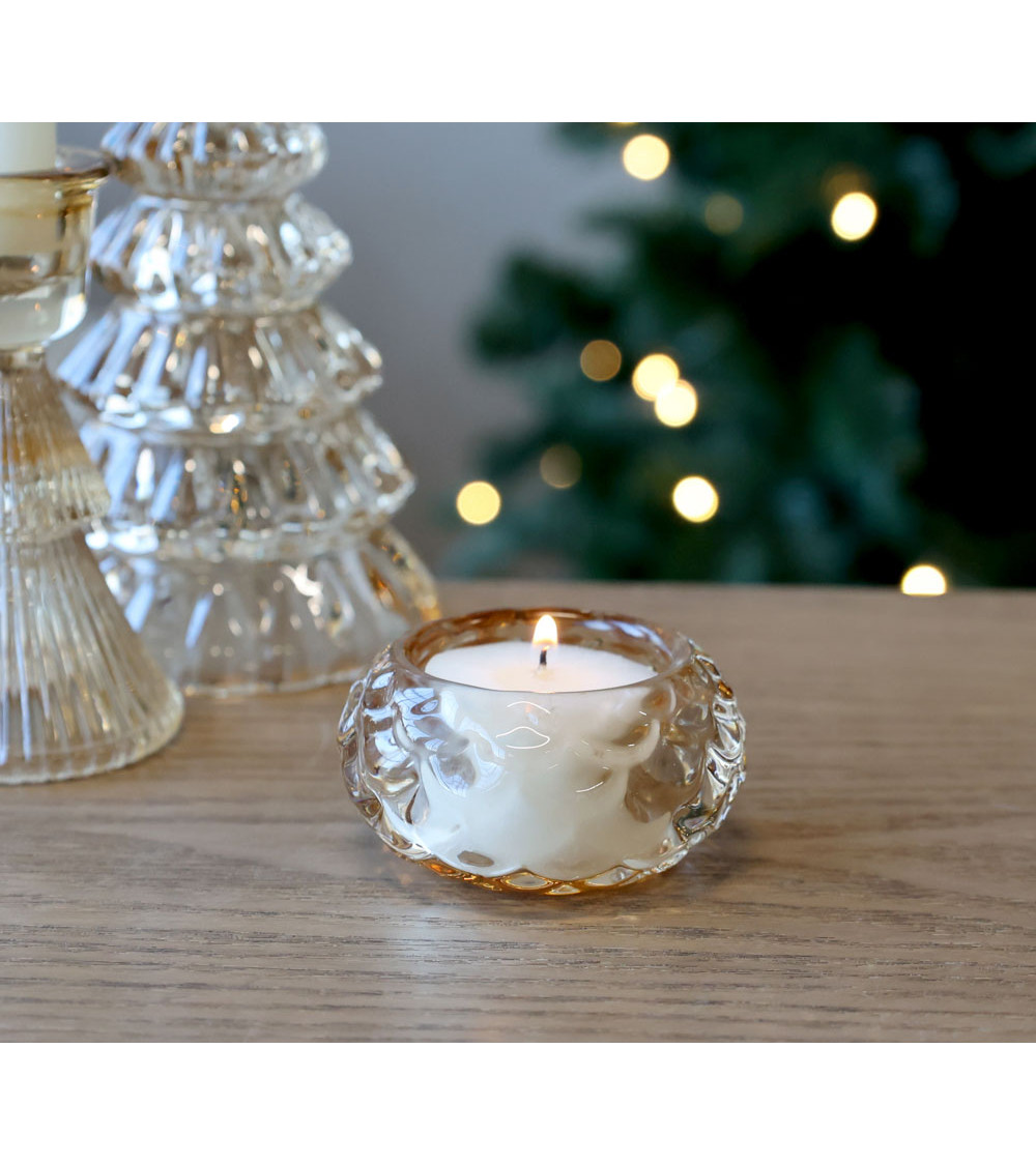 Photophore en verre ambré allumé, ambiance festive.