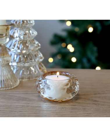 Photophore en verre ambré allumé, ambiance festive.