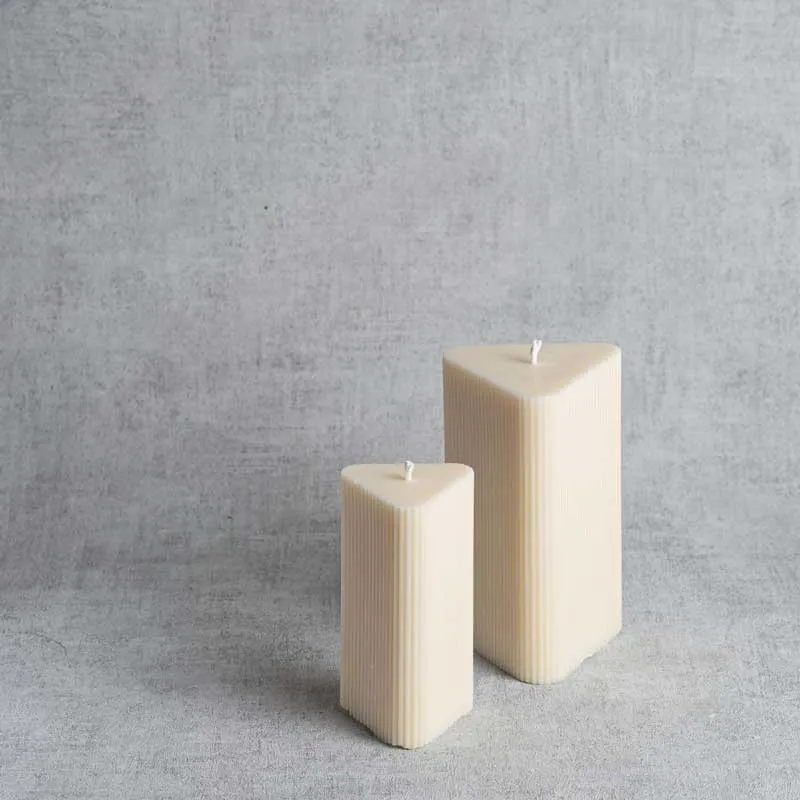 Duo de bougies rainurées en cire végétale, design triangulaire et finition crème.